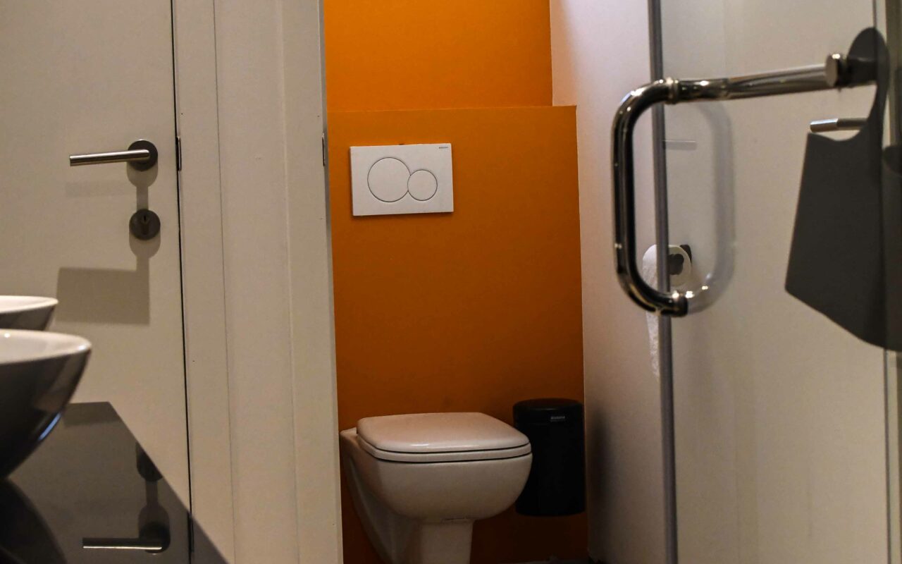 Badkamer met toilet, wastafels en douche in Vakantieverblijf De Backstage